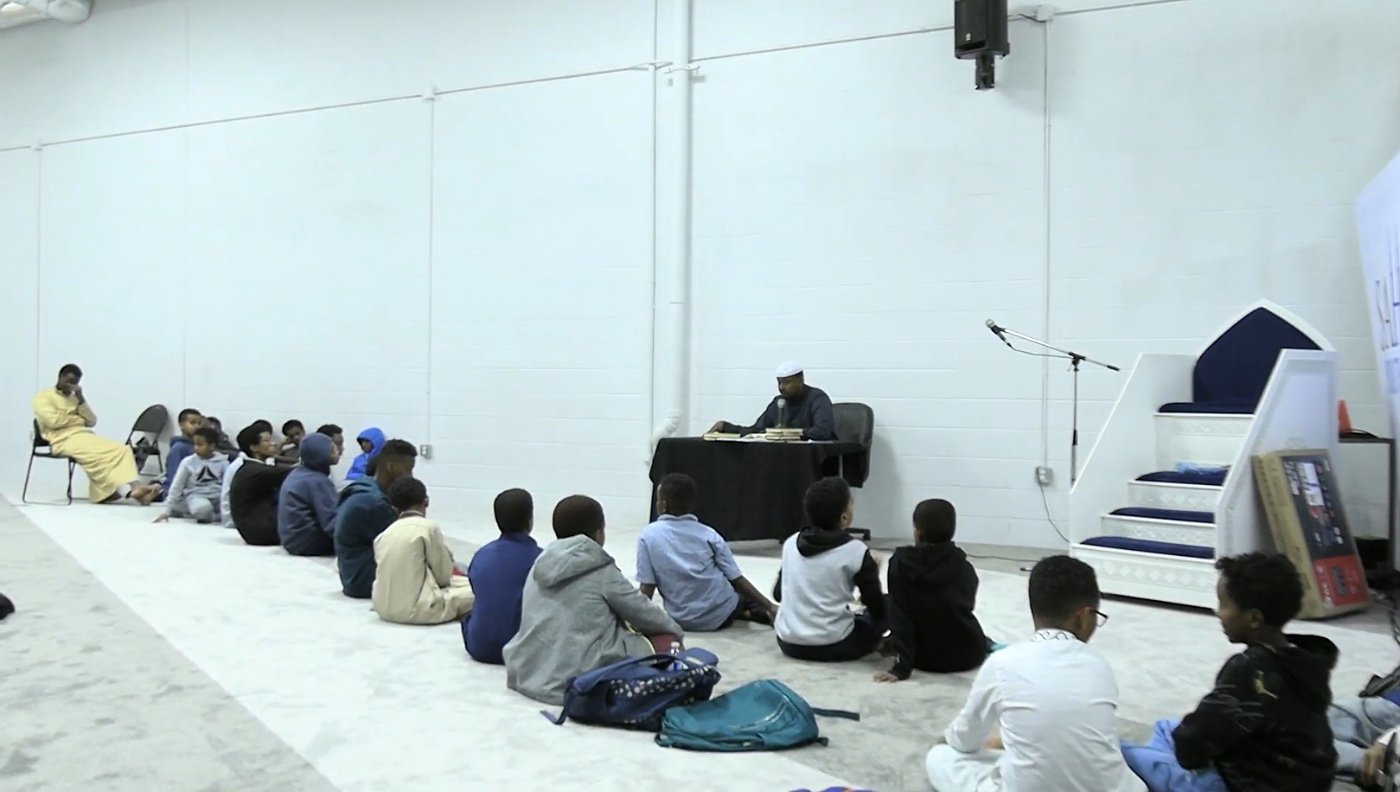 A young student reading from the mushaf